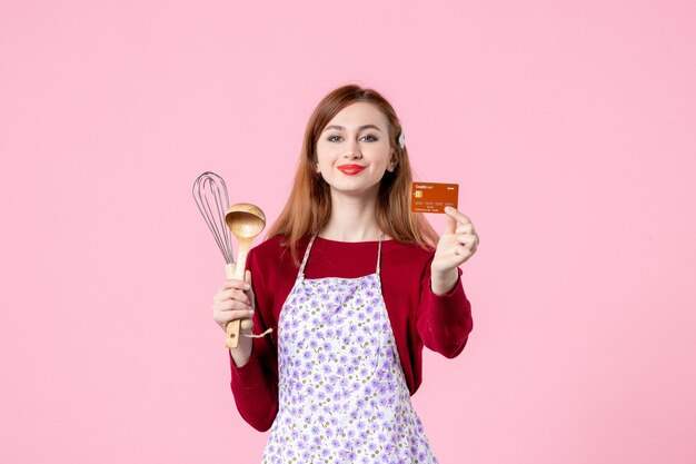 vooraanzicht jonge huisvrouw met garde en bankkaart op roze achtergrond vrouw kleur taart keuken winkelen koken keuken taart geld