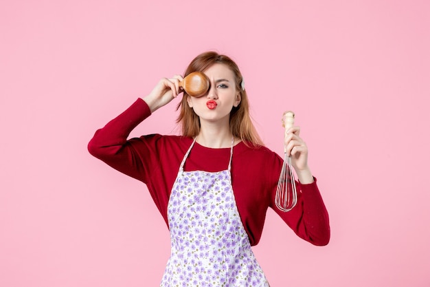 vooraanzicht jonge huisvrouw met garde en houten lepel op roze achtergrond keuken koken beroep vrouw taart taart uniform