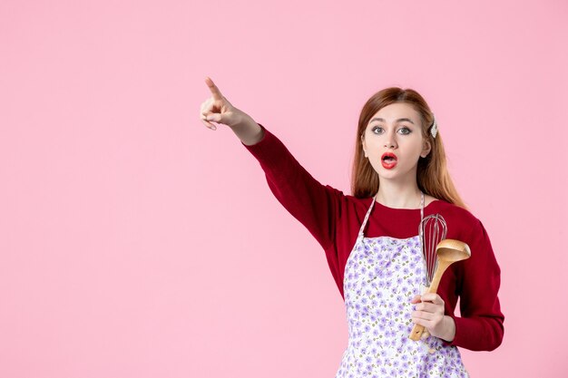 vooraanzicht jonge huisvrouw met lepel en garde op roze achtergrond zoete kleur koken keuken eten vrouw taart keuken deeg