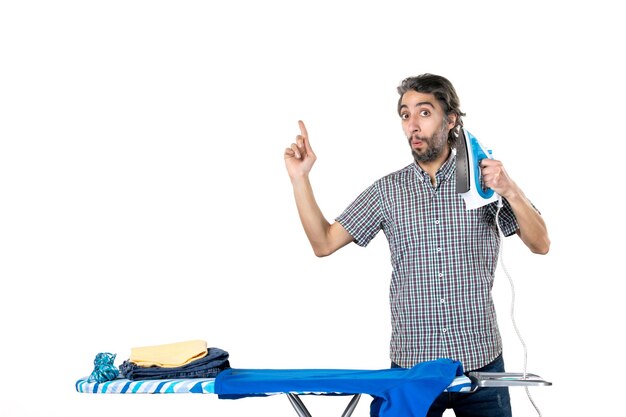 vooraanzicht jonge man bedrijf ijzer op witte achtergrond strijken huis man huishoudelijk werk machine schone kleren