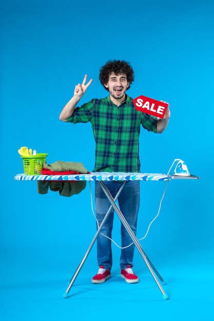 vooraanzicht jonge man bedrijf verkoop schrijven op blauwe achtergrond menselijke wasmachine kleur schoon winkelen huishoudelijk werk