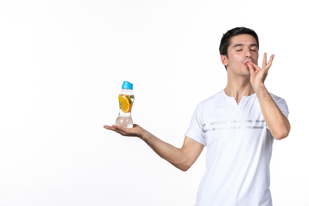 Vooraanzicht jonge man met fles limonade op witte achtergrond sap vers drankje huid fruit horizontale koeling ijs menselijke frisdrank vloeistof