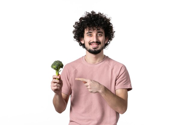 Vooraanzicht jonge man met kleine groene broccoli op witte achtergrond lichaam horizontaal gewicht plantaardig menselijk dieet gezondheid