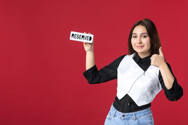 vooraanzicht jonge serveerster gereserveerd geschreven naambord op rode achtergrond uniforme kleur werk vrouw baan schoonheid restaurant maaltijd diner