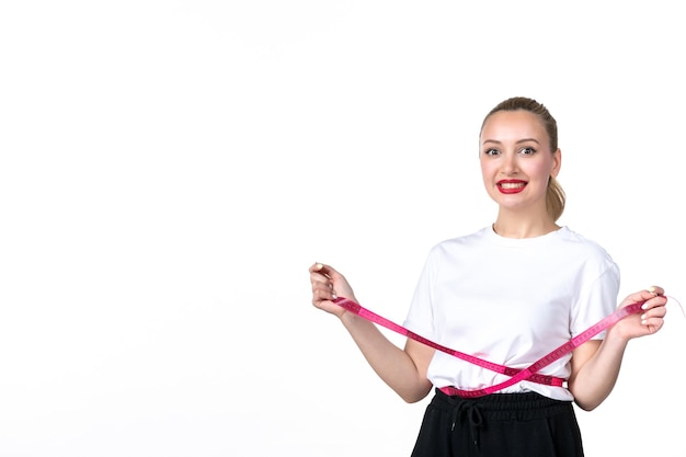 Vooraanzicht jonge vrouw die haar taille meet op een witte achtergrond huid torso taille meten schaal verliezen afslankende schoonheid