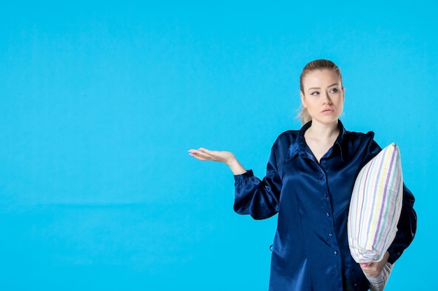 Foto vooraanzicht jonge vrouw in pyjama met kussen op blauwe achtergrond nachtmerrie feest kleur bed droom geeuw slaap nachtrust