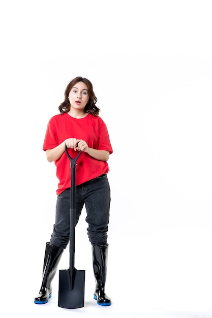 vooraanzicht jonge vrouw in rood shirt met zwarte schop op witte achtergrond bodem emotie graven werk begraafplaats grond vrouw job