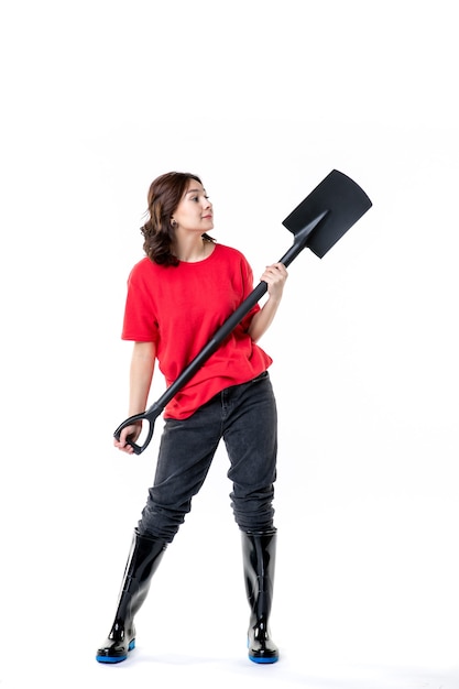 vooraanzicht jonge vrouw in rood shirt met zwarte schop op witte achtergrond grondkleur werk vrouw begraafplaats grond job