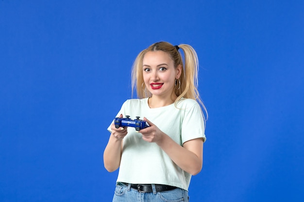 vooraanzicht jonge vrouw met gamepad op blauwe achtergrond vrolijke video volwassen speler joystick die online virtuele jeugd wint