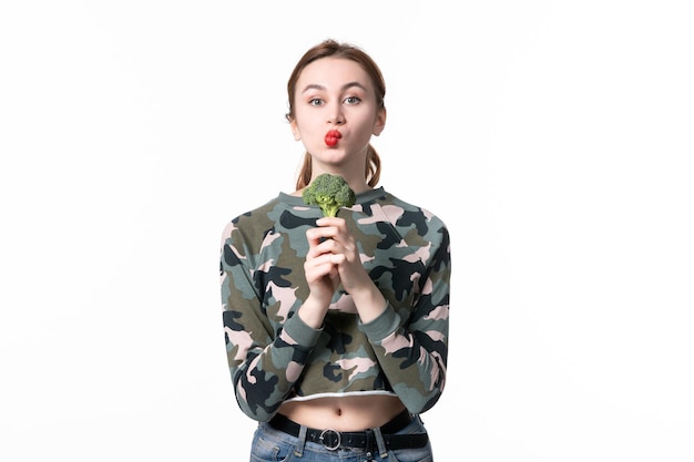 Vooraanzicht jonge vrouw met groene broccoli op witte achtergrond dieet gezondheid voedsel horizontale kleuren salade maaltijd lichaam lunch dish