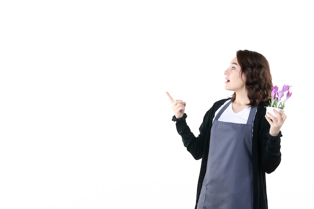 vooraanzicht jonge vrouw met paarse bloemen op witte achtergrond bodem natuur uniform tuin groen vrouw bloem emotie boom