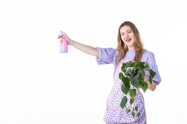 vooraanzicht jonge vrouw met pot met plant en spuitfles op witte achtergrond blad vrouw groen baan bloementuin gras natuur