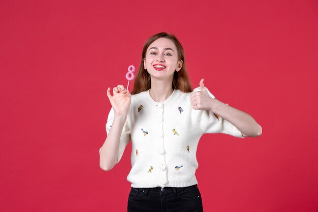 vooraanzicht jonge vrouw met roze sticker op rode achtergrond huwelijk mode vrouwendag sensueel maart winkelen liefde gelijkheid