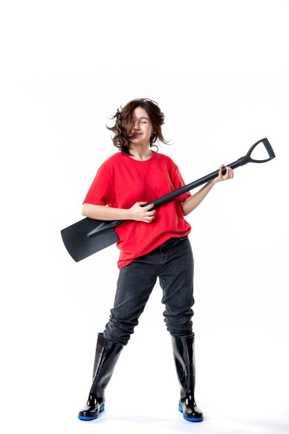 vooraanzicht jonge vrouw met zwarte schop als gitaar op de witte achtergrond werk grond graven emotie baan muziek band groep