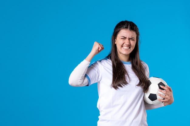 Vooraanzicht juichende jonge vrouw met voetbal