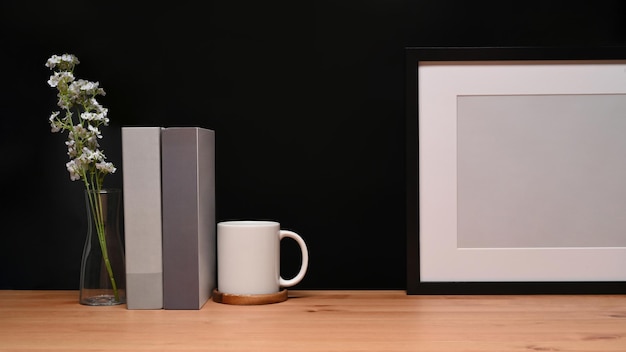 Vooraanzicht leeg frame koffiekopjes boeken en plant op houten tafel