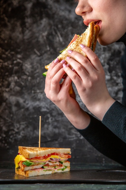 Vooraanzicht lekker broodje ham eten krijgen door vrouwtje op donkere ondergrond