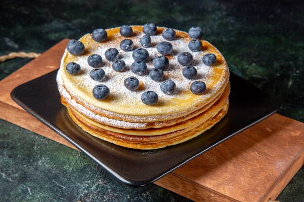 Vooraanzicht lekkere honingcake met bosbessen in plaat donker oppervlak