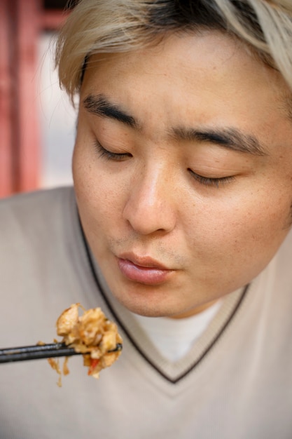 Vooraanzicht man eten met stokjes