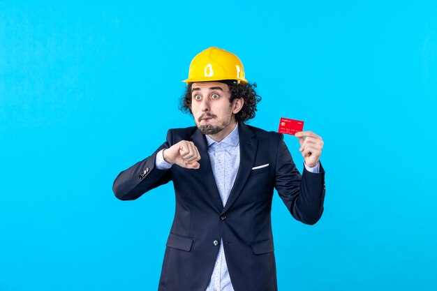 vooraanzicht mannelijke bouwer met bankkaart op blauwe achtergrond zakelijke architectuur werk constructeur gebouw kleur engineer