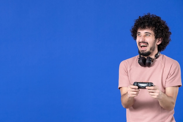 vooraanzicht mannelijke gamer die videogame speelt met gamepad op blauwe achtergrond winnende sofa jeugd volwassen vreugde virtuele speler tiener voetbal