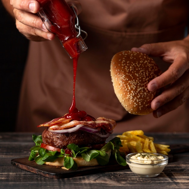 Foto vooraanzicht mannetje saus op hamburger zetten