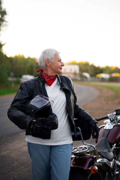 Foto vooraanzicht senior vrouw met motorfiets