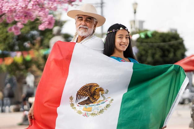 Foto vooraanzicht smiley man en meisje met mexicaanse vlag