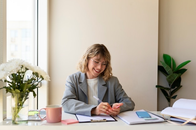 Vooraanzicht smiley vrouw die binnenshuis werkt