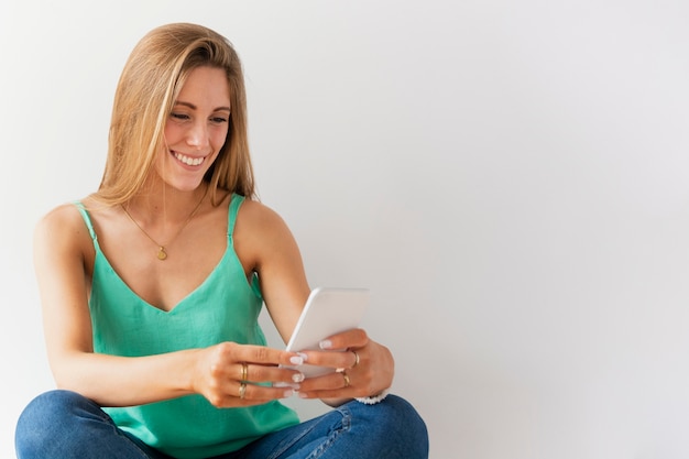 Vooraanzicht smiley vrouw met behulp van de telefoon