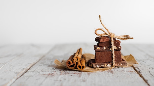 Vooraanzicht toren van chocolade snoepjes en kaneelstokjes op papieren zak