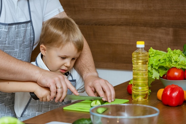 Vooraanzicht vader en zoon in de keuken gesneden groenten voor salade.