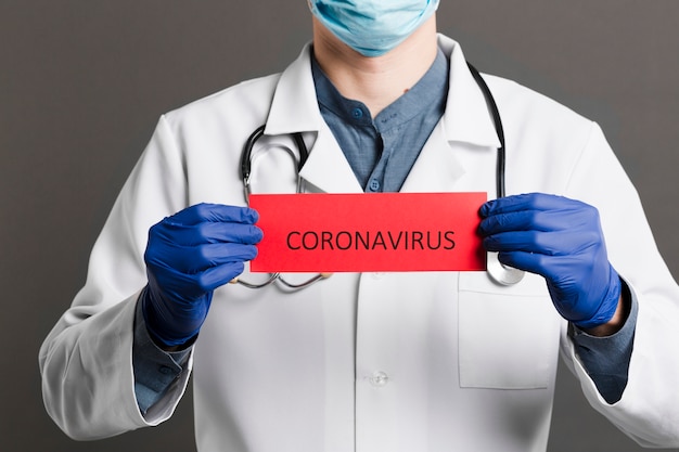 Foto vooraanzicht van arts met het document van de stethoscoopholding met coronavirus