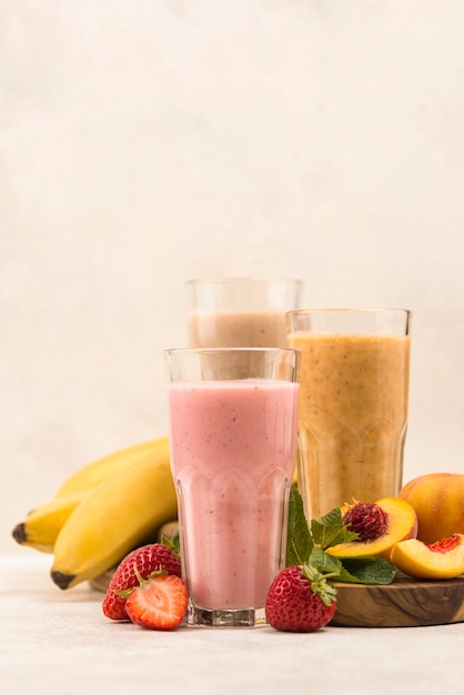 Vooraanzicht van assortiment milkshakes met fruit en kopie ruimte