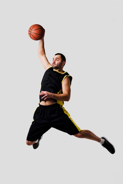 Foto vooraanzicht van basketbalspeler betrapt in de lucht dompelen