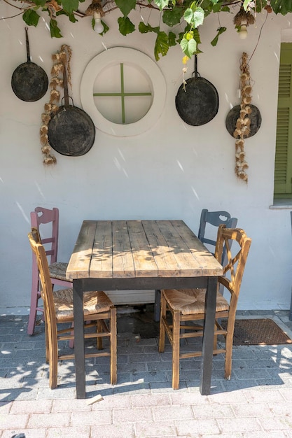 Vooraanzicht van de buitenkant van het kleine café tafel en lege stoelen buiten bij de witte muur toeristische plaatsen typisch mediterraan restaurant een vakantieplaats in de zomer