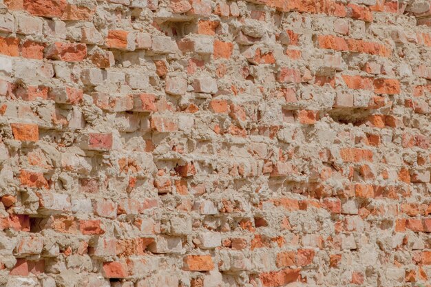 Vooraanzicht van de gebarsten rode kleibakstenen muur van een woongebouw