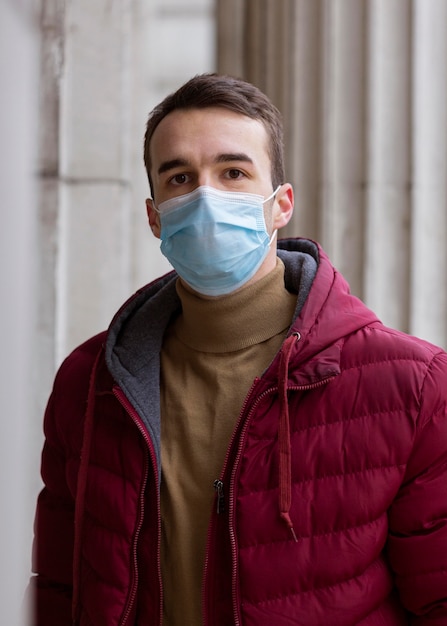 Foto vooraanzicht van de mens die buitenshuis met medische masker poseren