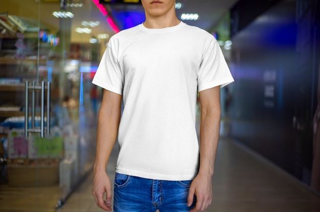 Vooraanzicht van een wit t-shirt mockup-ontwerp op een jonge kerel. Sjabloon voor presentatie in de winkel.