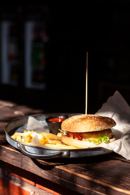 Vooraanzicht van hamburger op plaat met frietjes en kopie ruimte