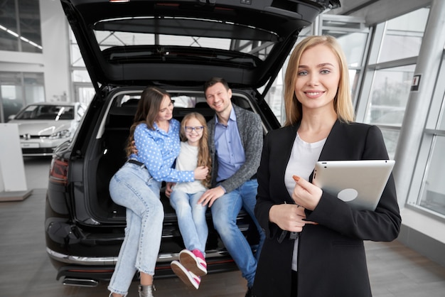 Vooraanzicht van het professionele autohandelaar stellen in autosalon