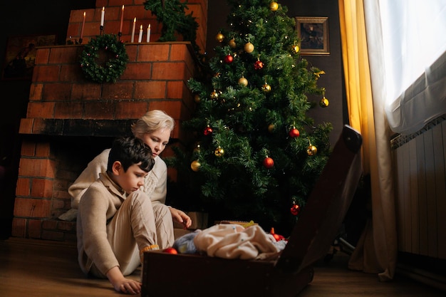 Vooraanzicht van jonge moeder en schattige kindzoon die versierd is met kleurrijke kerstballen