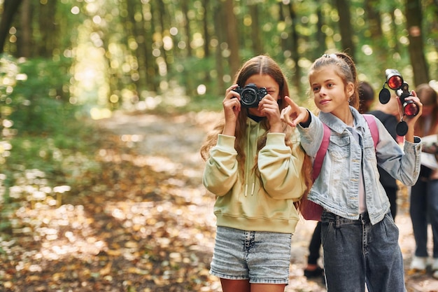 Vooraanzicht van kinderen die samen in de zomer overdag in het groene bos zijn