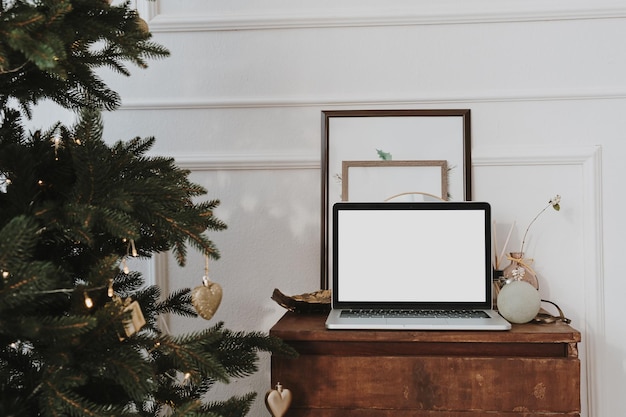 Vooraanzicht van laptopcomputer met blanco scherm kopieerruimte Kerstboom met versieringen Thuiswerken