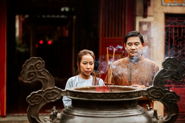 Foto vooraanzicht van man en vrouw met wierook bij de tempel