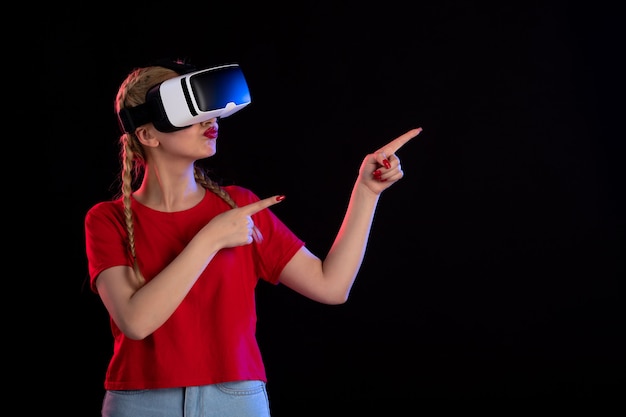 Vooraanzicht van mooie vrouw die vr speelt op donkere visuele echografiegamesfantasie