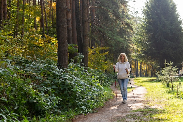 Vooraanzicht van oudere vrouw buitenshuis wandelen