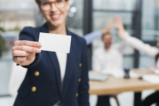 Vooraanzicht van personeelsvrouw die adreskaartje steunt