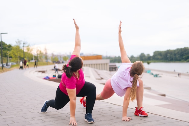 Vooraanzicht van professionele vrouwelijke fitnesstrainer heeft persoonlijke training met positief overgewicht