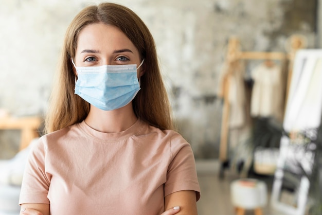 Vooraanzicht van vrouw die medisch masker met exemplaarruimte draagt